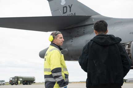 2 men standing by a jet