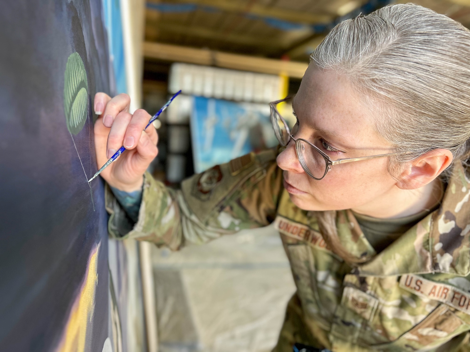 Maryland Air National Guard Staff Sgt. Rachel Underwood, public affairs specialist for the 175th Wing, paints her acrylic mural at Warfield Air National Guard Base at Martin State Airport, Maryland, March 1, 2025.