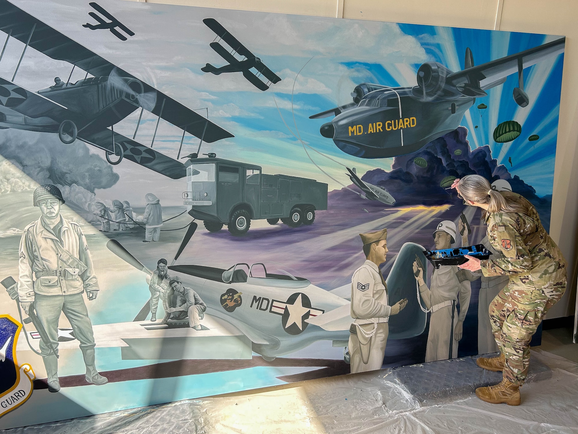 cMaryland Air National Guard Staff Sgt. Rachel Underwood, public affairs specialist for the 175th Wing, paints finishing touches to her acrylic mural at Warfield Air National Guard Base at Martin State Airport, Maryland, March 1, 2025.