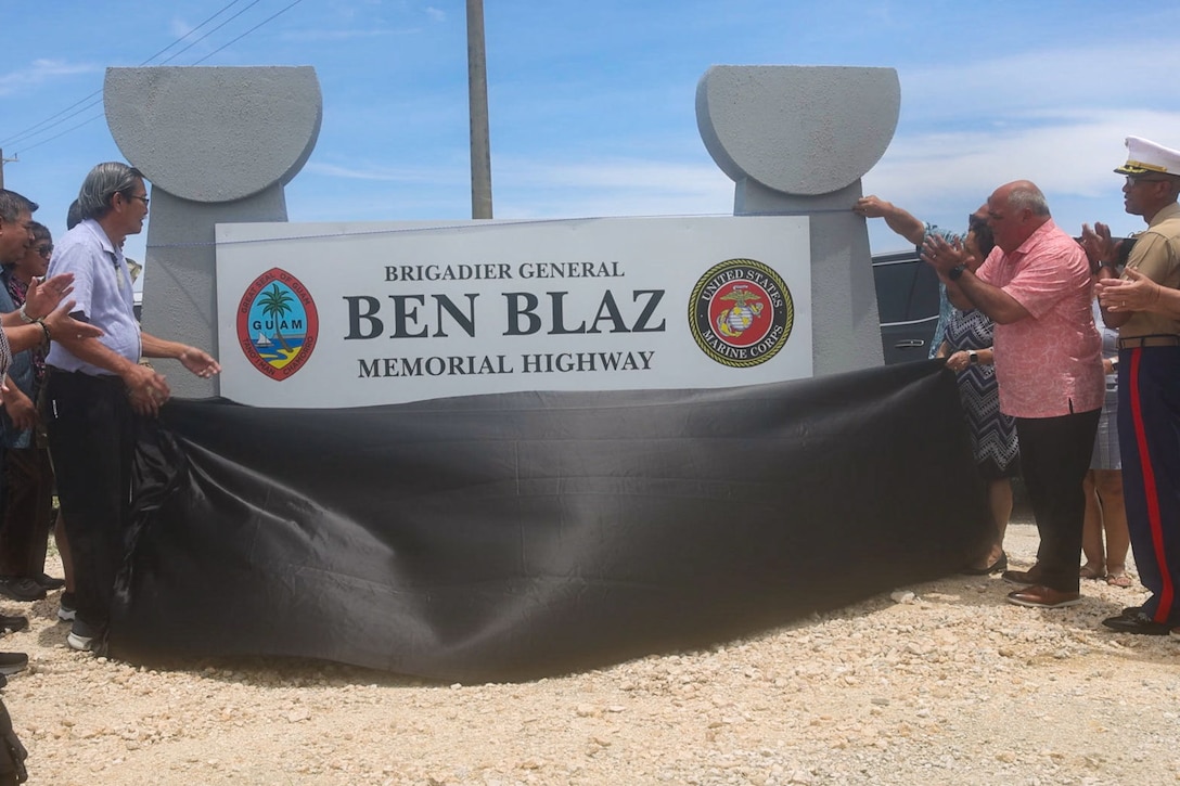 U.S. Marine Corps Col. Richard D. Marshall Jr., commanding officer of Marine Corps Base Camp Blaz and Guam Government officials reveal the new highway sign during the Brig. Gen. Ben Blaz Memorial Highway renaming ceremony in Dededo, Guam, July 28, 2025. The naming of Brig. Gen. Ben Blaz Memorial Highway is a heartfelt tribute to a distinguished individual who represents the dedication to service, professionalism, and local pride that Camp Blaz aspires to uphold. (U.S. Marine Corps photo by Lance Cpl. Afton Smiley)