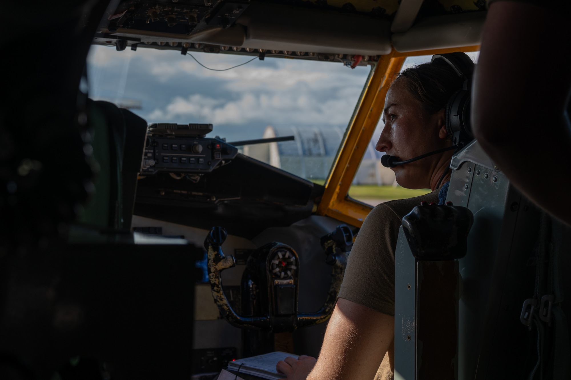 A female military pilot sits in a cockpit