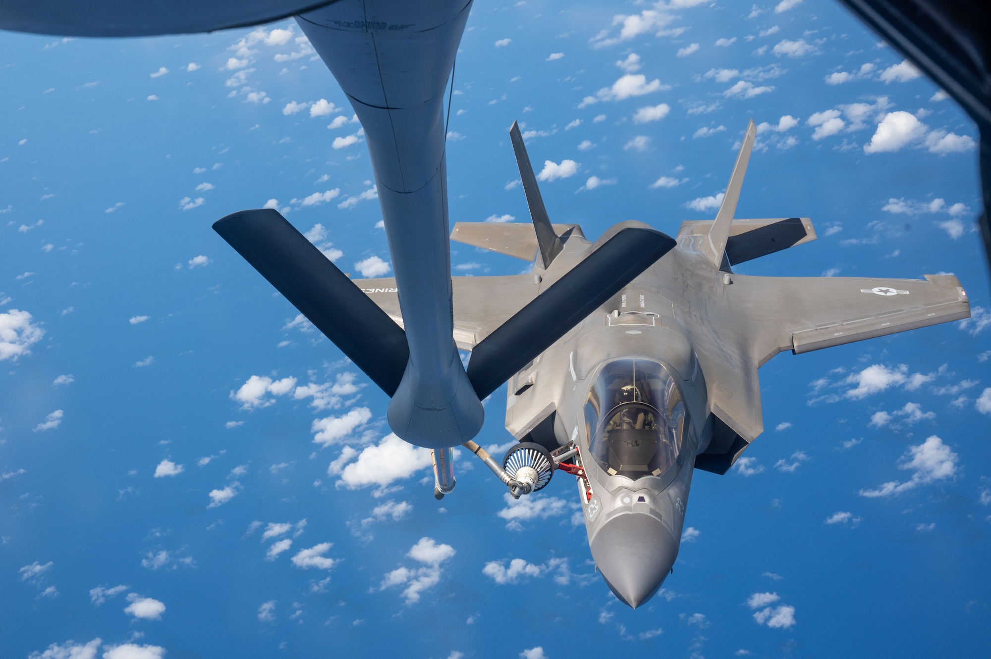 A F-35B aircraft flies next to a KC-135 aircraft retractable probe for refueling