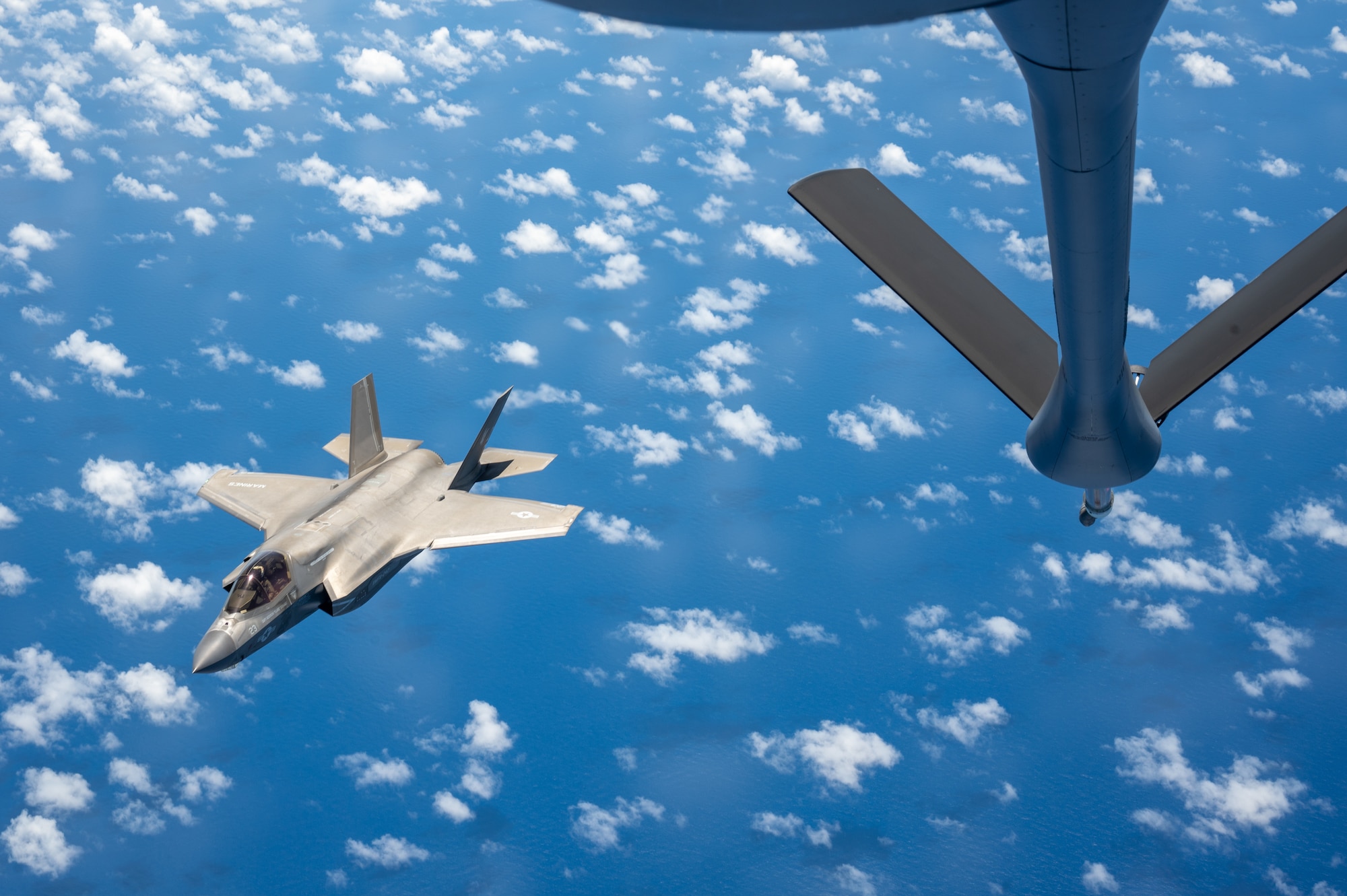A F-35B aircraft flies away from a KC-135 aircraft after refueling