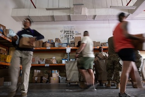 U.S. Air Force members assigned to the 379th Expeditionary Force Support Squadron sort mail within the U.S. Central Command area of responsibility, Aug. 6, 2025. Airmen assigned to the 379th EFSS Postal Office and volunteers worked together to process a large delivery of mail. (U.S. Air Force photo by Senior Airman Dieondiere Jefferies)