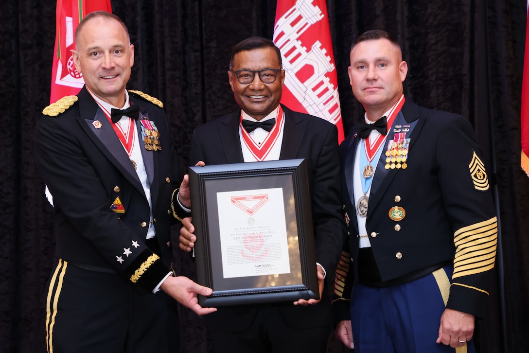 Lt. Gen. (Ret.) Thomas Bostick, the 53rd Chief of Engineer stands in a tuxedo between Lt. Gen. William H. "Butch" Graham, the 56 Chief of Engineers, and Command Sgt. Major Douglas Galick, the 15th Command Sgt. Major of the U.S. Army Corps of Engineers, both in their Army dress blue uniforms.