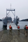 Soldiers prepare a logistics support vessel to receive cargo before the start of a mission in Baltimore, Maryland that is traveling to Washington state.