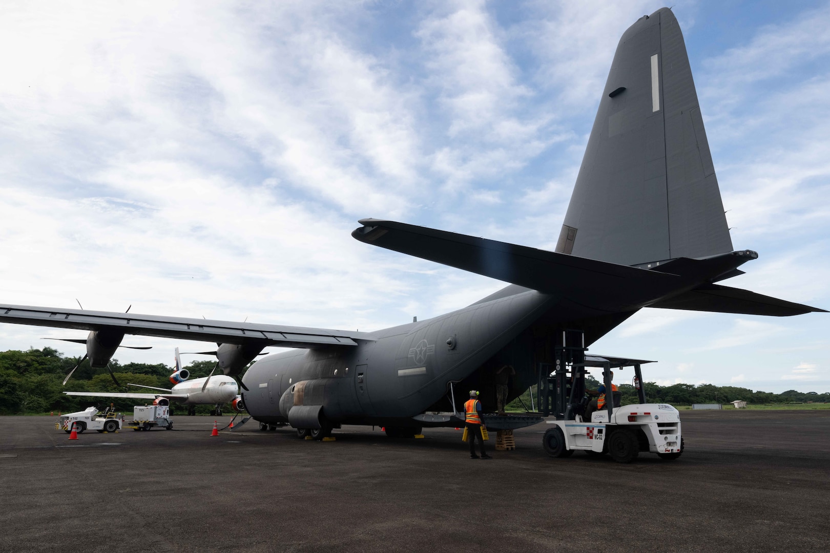 A U.S. Air Force C-130J Hercules is being unloaded at an airstrip in Panama.