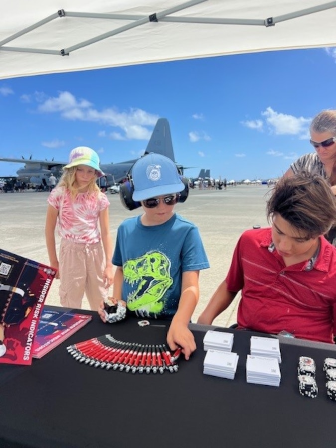 Insider Threat Analyst Joey Borgardt engages the crowd and hands out awareness materials at the MCB Hawaii airshow.