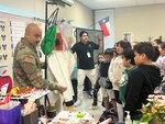 Capt. Jesus Silvas, a microbiologist with the U.S. Army Reserve Medical Command assigned to the 59th Medical Wing’s Office of Research and Technology Applications, shows students a Biosafety Level 4 Positive Pressure Suit Aug. 7, 2025, at Mendez Elementary School in San Marcos, Texas, as Dr. Israel Guerrero, a virologist with Texas Biomedical Research Institute, explains its use.