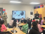 Capt. Jesus Silvas, a microbiologist with the U.S. Army Reserve Medical Command assigned to the 59th Medical Wing’s Office of Research and Technology Applications, and Dr. Israel Guerrero, a virologist with Texas Biomedical Research Institute, speak to students Aug. 7, 2025, at Mendez Elementary School in San Marcos, Texas