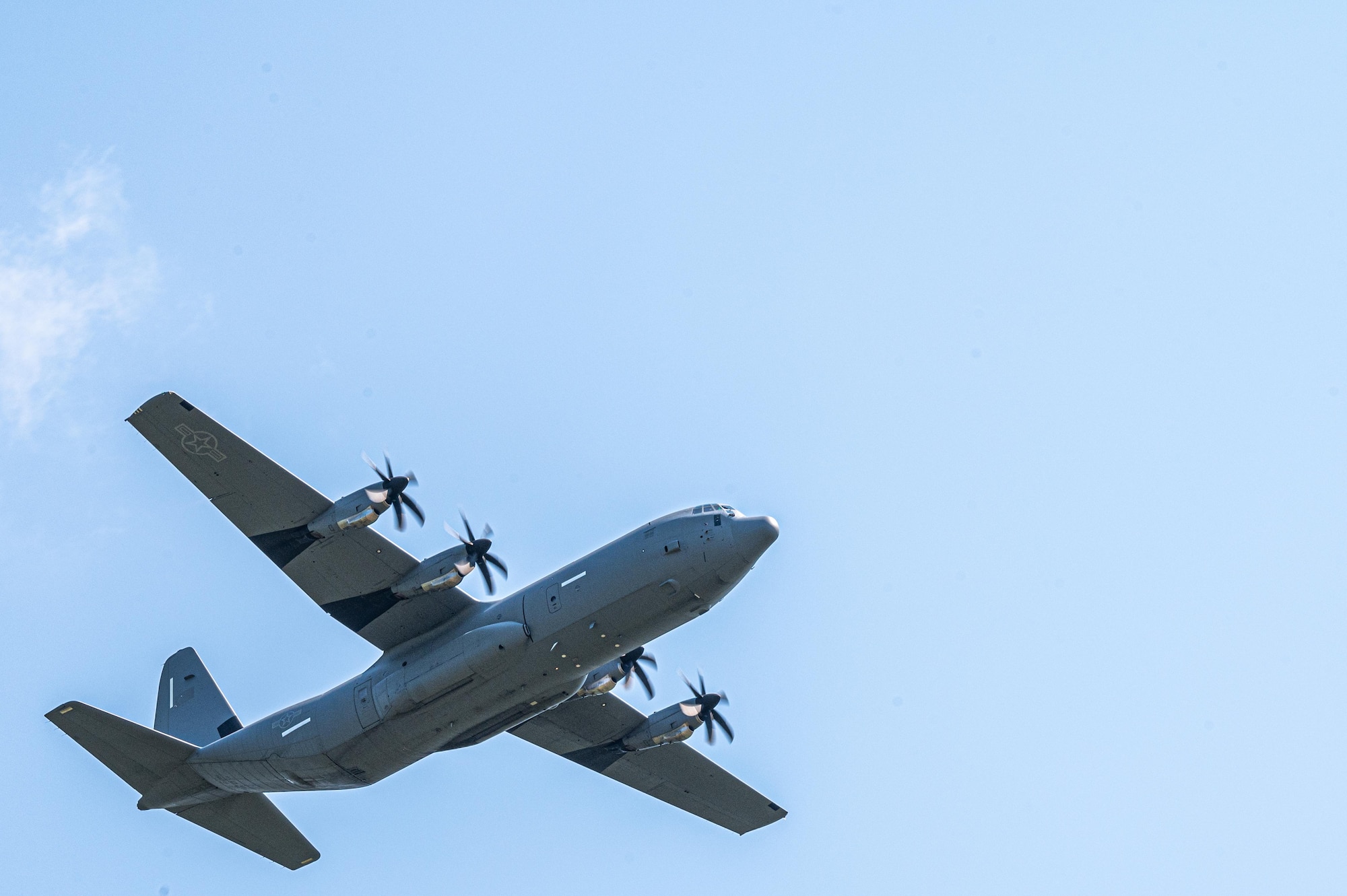 A U.S. Air Force C-130J Super Hercules assigned to the 61st Airlift Squadron flies over a landing zone during exercise Bamboo Eagle 25-3 at Camp Robinson, Arkansas, August 4, 2025. Landing zone operations are a key element of Agile Combat Employment, supporting dispersed and resilient force projection. (U.S. Air Force photo by Airman 1st Class Adrien Tran)