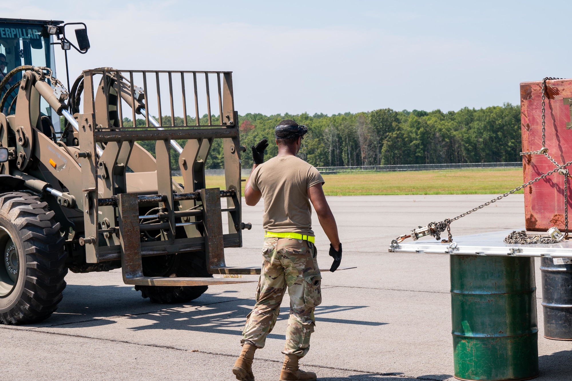 U.S. Air Force Staff Sgt. Jeffrey James III, 21st Combat Air Base Squadron load planning supervisor, directs a forklift toward cargo during exercise Bamboo Eagle 25-3 at Camp Robinson, Arkansas, August 4, 2025. BE 25-3 allowed Airmen assigned to the 21st CABS to build and refine landing zone procedures in austere environments. (U.S. Air Force photo by Airman 1st Class Adrien Tran)