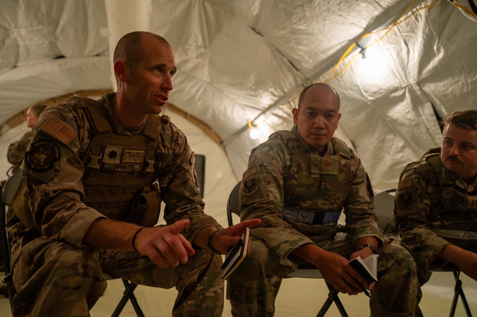 U.S. Air Force Lt. Col. Nathaniel White, 21st Combat Air Base Squadron commander, discusses exercise operations during exercise Bamboo Eagle 25-3 at Camp Robinson, Arkansas, Aug. 6, 2025. 21st Air Task Force leadership designed realistic scenarios to challenge Airmen decision-making and adaptability to mirror real-world mission demands. (U.S. Air Force photo by Airman 1st Class Adrien Tran)