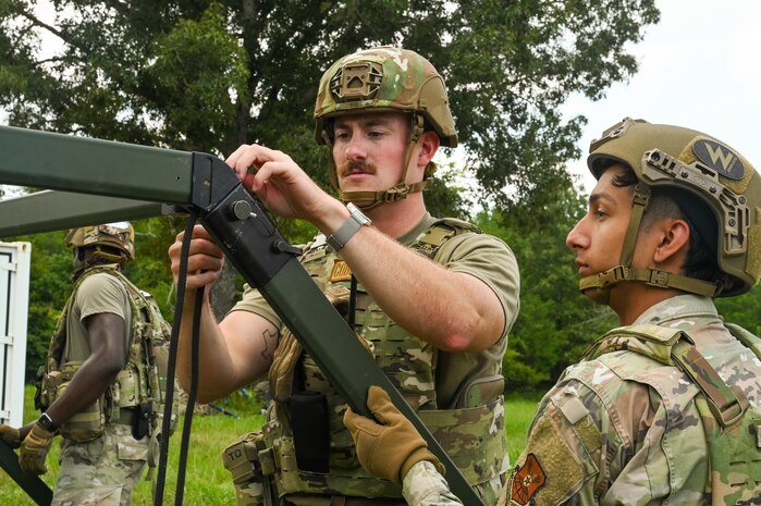 U.S. Air Force Airmen assigned to the 21st Combat Air Base Squadron assemble a tent at a forward operating site during exercise Bamboo Eagle 25-3 at Camp Robinson, Arkansas, August 2, 2025. Exercise BE 25-3 challenges the 21st Air Task Force to think critically and creatively to showcase their ability to adapt and innovate in the face of dynamic operational demands. (U.S. Air Force photo by Airman 1st Class Adrien Tran)