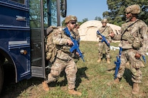 U.S. Air Force Airmen assigned to the 21st Combat Air Base Squadron unload from a bus at  a forward operating site during exercise Bamboo Eagle 25-3 at Camp Robinson, Arkansas, August 3, 2025. BE 25-3 strengthens Airmen’s readiness by reinforcing  continuous improvement and preparing them for multidimensional challenges. (U.S. Air Force photo by Airman 1st Class Adrien Tran)