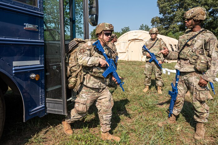 U.S. Air Force Airmen assigned to the 21st Combat Air Base Squadron unload from a bus at  a forward operating site during exercise Bamboo Eagle 25-3 at Camp Robinson, Arkansas, August 3, 2025. BE 25-3 strengthens Airmen’s readiness by reinforcing  continuous improvement and preparing them for multidimensional challenges. (U.S. Air Force photo by Airman 1st Class Adrien Tran)