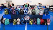 Backpacks sit on a table for the Back-to-School Supplies Brigade.