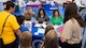 Military families are checked-in at a table during the Back-to-School Supplies Brigade.