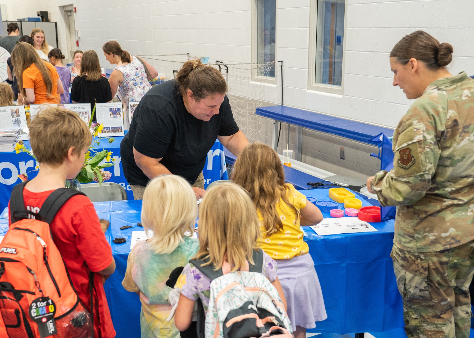 A military family interacts with Minot Air Force Base Environmental’s table during the Back-to-School Supplies Brigade.