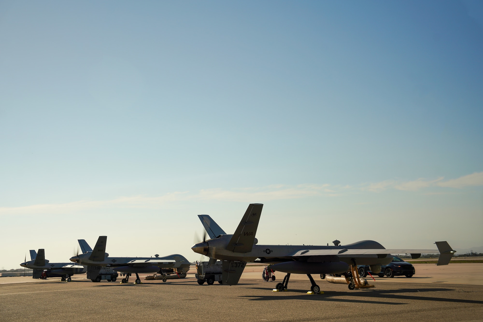 Three MQ-9 Reaper remotely piloted aircraft sit parked.