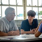 Russell Risch, an engineer at Pearl Harbor Naval Shipyard and Maintenance Facility discusses design concepts with Junior Engineers, Summer STEM Experience (JESSE) intern Ethan Chow during a group activity in the iLab, June 12, 2025.
