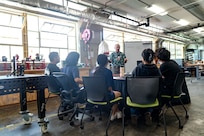 Sy Shimabukuro, an engineer at Pearl Harbor Naval Shipyard and Maintenance Facility explains troubleshooting principles to interns from the Junior Engineers Summer STEM Experience (JESSE) program during a hands-on workshop in the iLab, June 12, 2025.