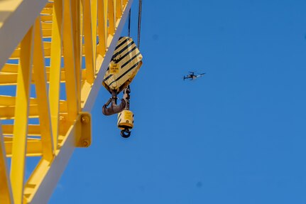 A Skydio X10D drone hovers near a crane during a demonstration at Pearl Harbor Naval Shipyard & Intermediate Maintenance Facility, Hawaii, June 18, 2025.