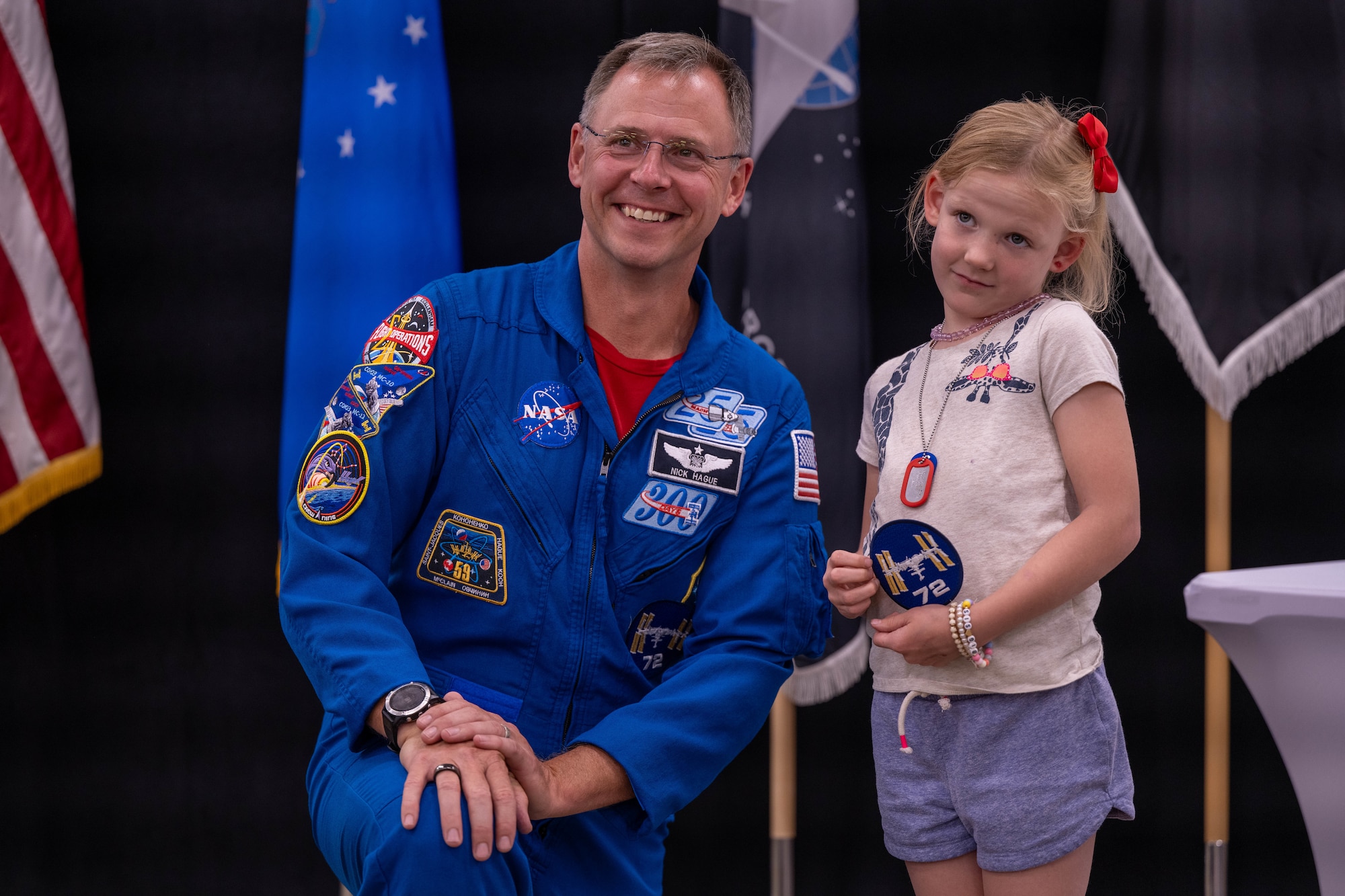 astronaut poses with little girl