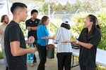 Engineer Traci Sunada from Pearl Harbor Naval Shipyard and Intermediate Maintenance Facility talks with a student from the Honolulu Community College CTE Academy during a community event at the Pacific Fleet Submarine Museum July 15, 2025.