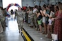 An Airman walking down an aisle of people during a celebration.
