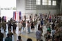 Airmen and civilians gathered together inside of a hangar for a celebration