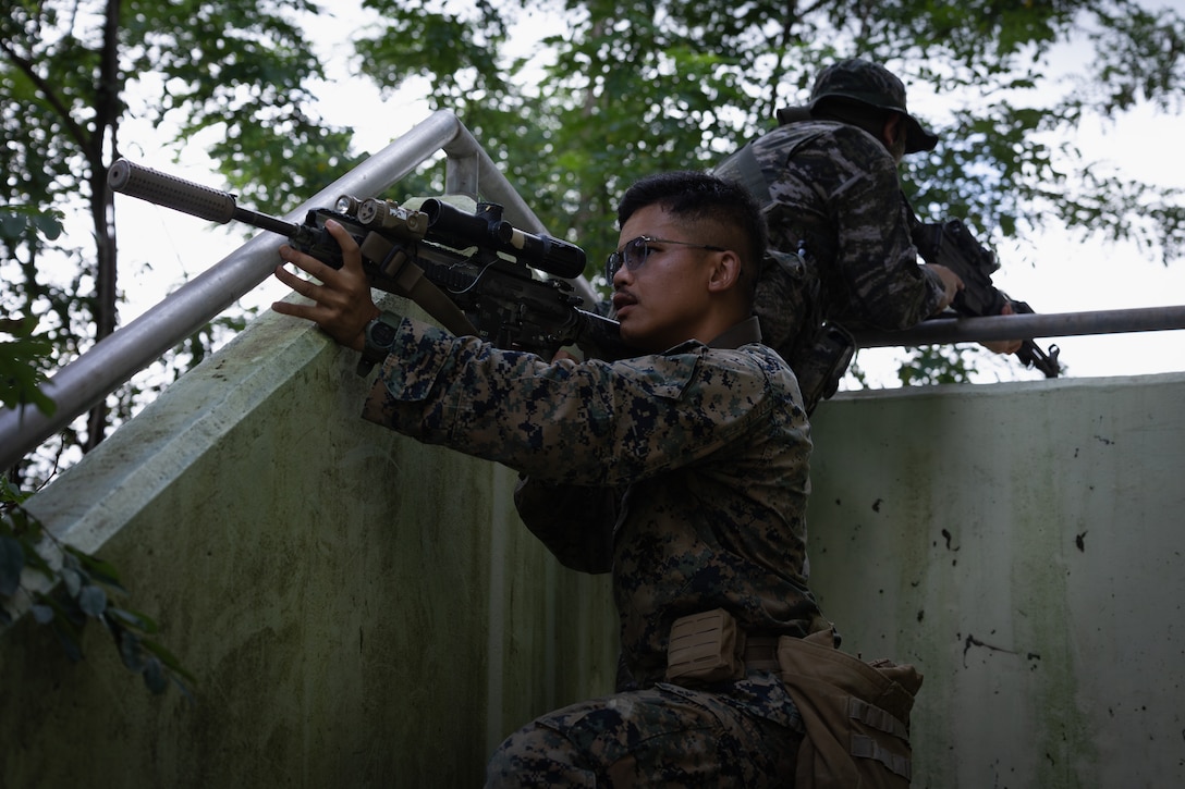 U.S. Marine Corps Lance Cpl. Natthakit Chuaytua, a rifleman with 2nd Battalion, 23rd Marines, forward deployed with 4th Marine Regiment, 3d Marine Division as part of the Unit Deployment Program, provide security with a Republic of Korea Marine during military operations in urban terrain training during the Korean Marine Exchange Program 25.2 in Pocheon, South Korea, July 22, 2025. KMEP is conducted regularly between the ROK and U.S. Marine Corps to increase their combined capabilities through realistic training geared towards deterring threats and maintaining peace in the Indo-Pacific. (U.S. Marine Corps photo by Lance Cpl. Van Hoang)
