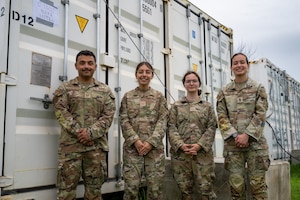 U.S. Airmen assigned to the 19th Operations Support Squadron and 317th OSS are photographed in front of a conex building at Andersen Air Force Base, Guam, during the Air Force’s 2025 Department-Level Exercise series, July 26, 2025. The DLE series is a new way of conducting operations in a contested, dynamic environment to build capabilities making a stronger, deterrent force. The DLE encompasses all branches of the Department of Defense, along with Allies and partners, employing more than 400 Joint and coalition aircraft and more than 12,000 members at more than 50 locations across 3,000 miles. (U.S. Air Force photo by Senior Airman Jade M. Caldwell)