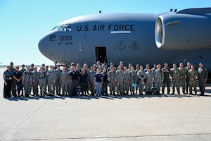 U.S. Air Force Airmen from the 58th Airlift Squadron (AS) take a group photo with Civil Air Patrol (CAP) cadets at Altus Air Force Base, Oklahoma, Aug. 6, 2025. CAP cadets were given an incentive flight by members from the 58th AS, featuring low-level maneuvers and a tour of a C-17 Globemaster III aircraft. (U.S. Air Force photo by Airman 1st Class Nathan Langston)
