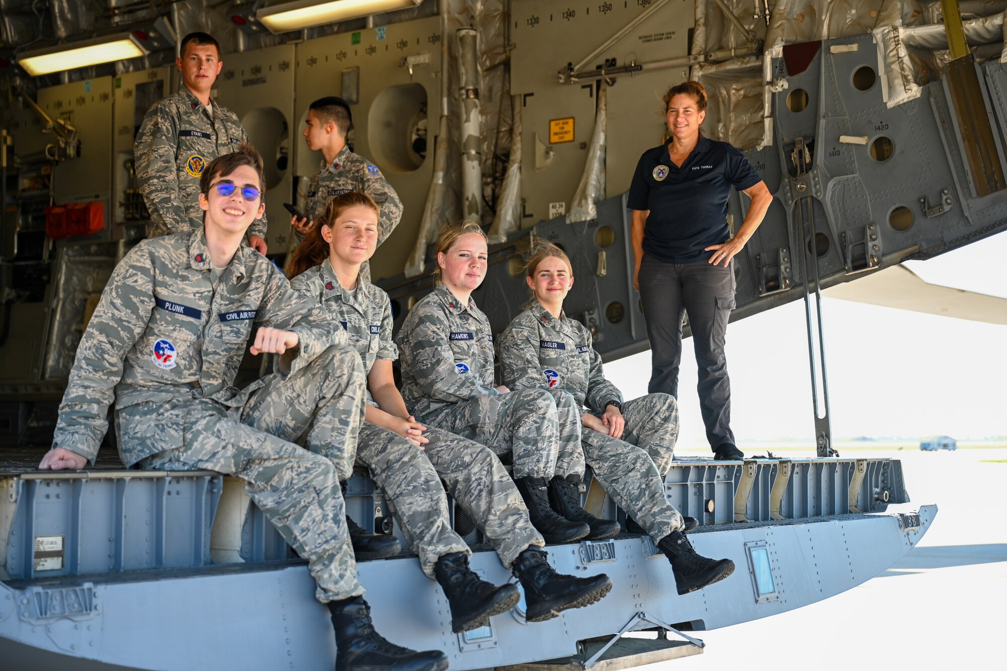 Civil Air Patrol (CAP) cadets sit on the ramp of a U.S. Air Force C-17 Globemaster III aircraft at Altus Air Force Base, Oklahoma, Aug. 6, 2025. Established in 1941, CAP is a public service organization chartered by congress that functions both as a nonprofit and the civilian auxiliary of the Air Force. (U.S. Air Force photo by Airman 1st Class Nathan Langston)