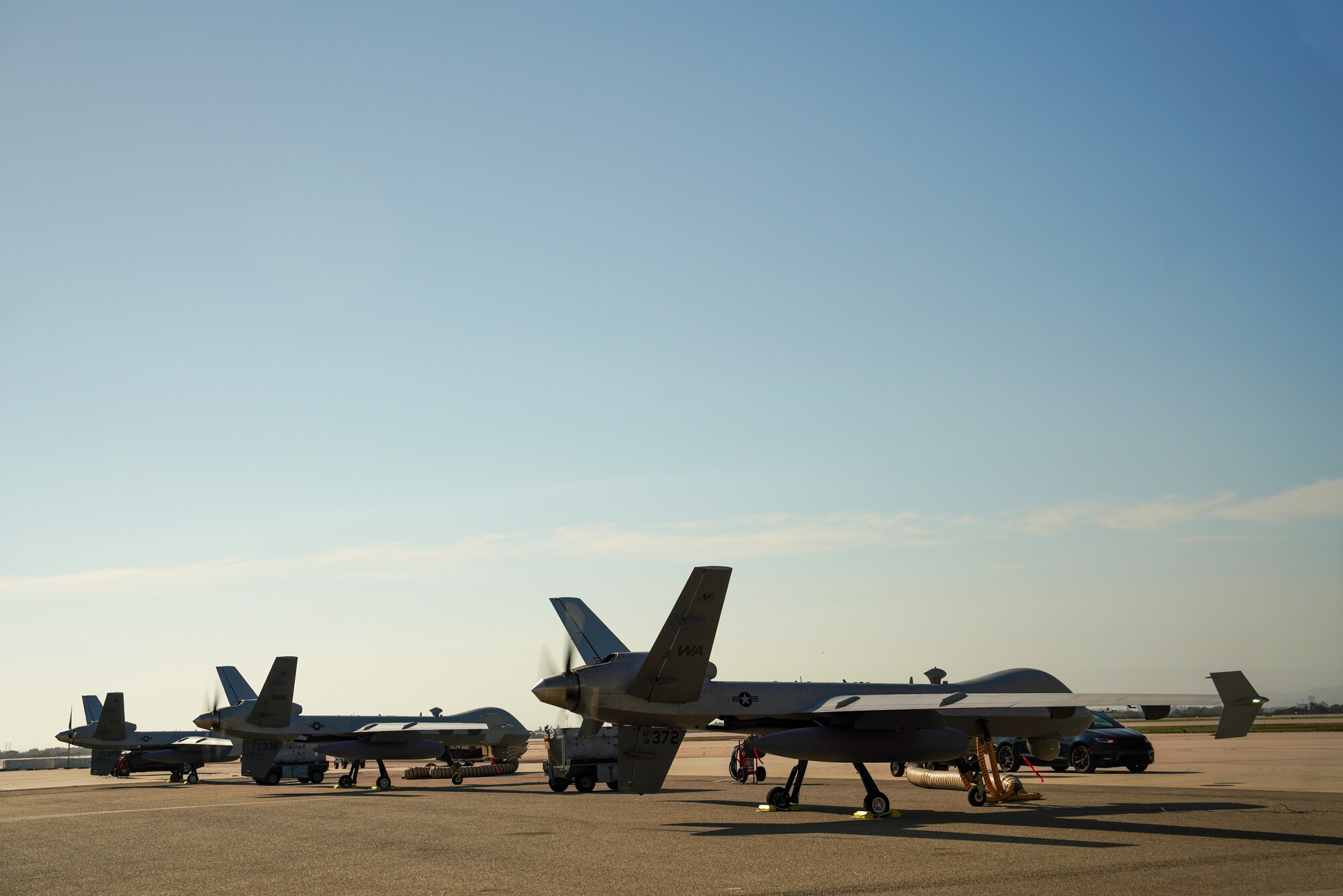 Three MQ-9 Reaper remotely piloted aircraft sit parked.