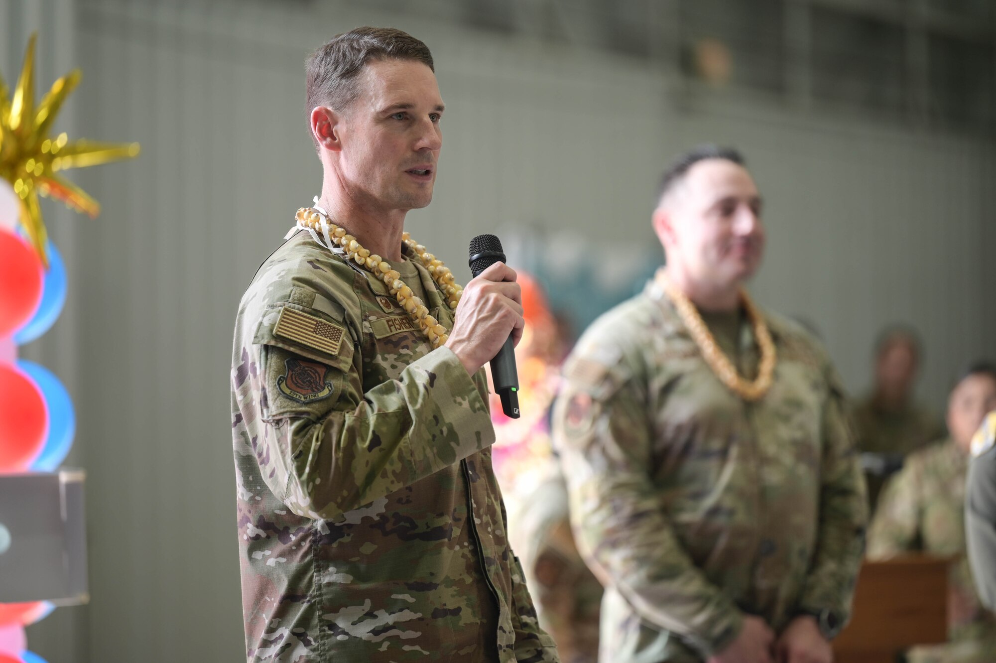 An Airman giving a speech while holding a microphone.