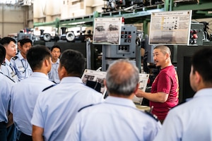 A group of people surrounding warehouse equipment