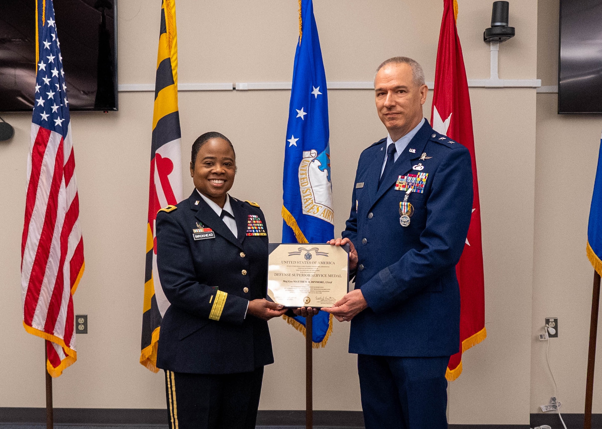Maryland Army National Guard Maj. Gen. Janeen Birckhead, adjutant general for Maryland, presents Maj. Gen. Matthew D. Dinmore,  the National Guard assistant to the commander, U.S. Cyber Command, and director, National Security Agency and Central Security Service, with the Defense Superior Service Medal during his retirement ceremony at Warfield Air National Guard Base at Martin State Airport, August 10, 2025. The medal recognizes superior meritorious service in a position of significant responsibility. (U.S. Air National Guard photo by Airman 1st Class Sarah Hoover)
