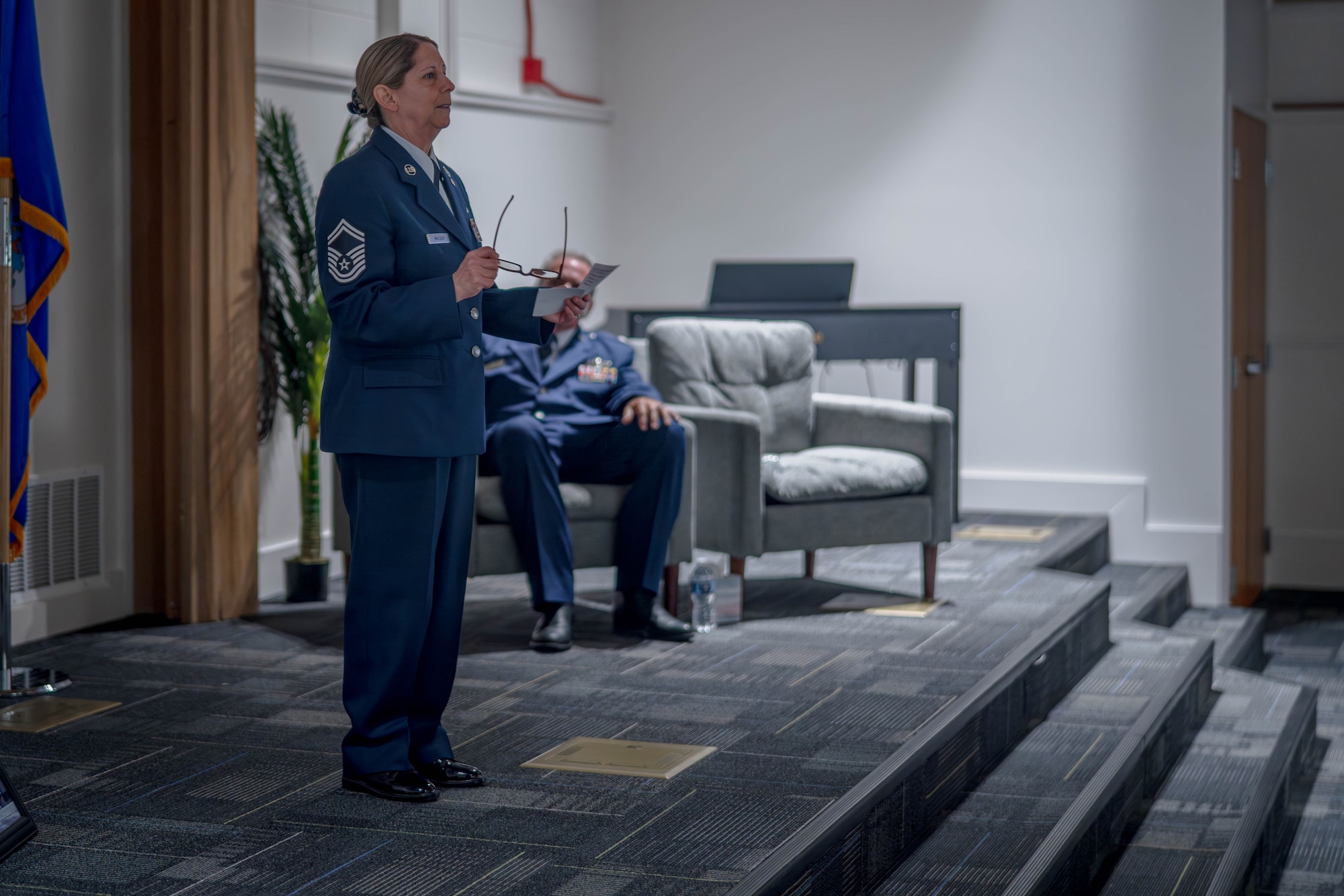 Senior Master Sgt. Spring Walden stands on stage and addresses the attendees of her retirement ceremony.