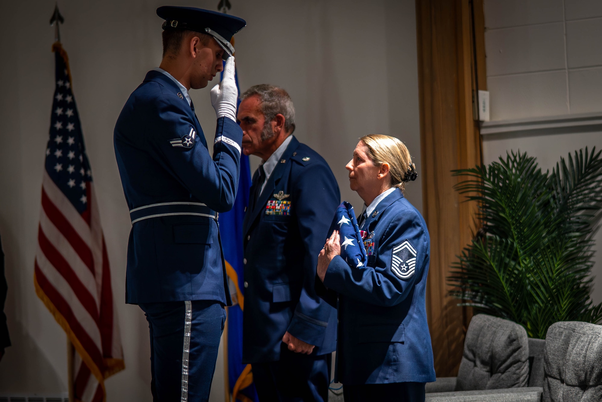 Senior Master Sgt. Spring Walden receiving folded flag from honor guard during retirement ceremony. 