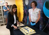STARBASE leaders cut a cake following the ribbon-cutting ceremony