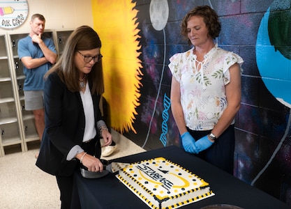 STARBASE leaders cut a cake following the ribbon-cutting ceremony