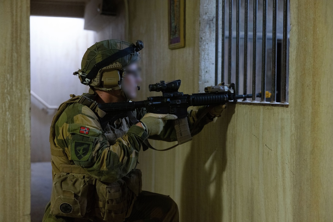 A Norwegian soldier with STA Batttery, Artillery Battalion posts security during exercise Burmese Chase 25 at Marine Corps Base Camp Lejeune, North Carolina, Aug. 8, 2025. Burmese Chase is an annual U.S. led, multi-lateral training exercise comprised of integrating ground and air fires, infantry tactics and naval gunfire alongside NATO allies to enhance combat readiness and interoperability. (U.S. Marine Corps photo by LCpl. Weston Lindstrom) (This photo has been altered for security purposes by blurring out faces.)