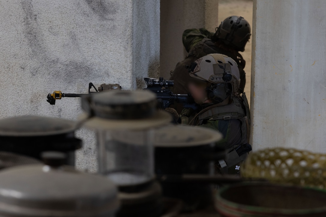 A Swedish armed forces member posts security during exercise Burmese Chase 25 at Marine Corps Base Camp Lejeune, North Carolina, Aug. 8, 2025. Burmese Chase is an annual U.S. led, multi-lateral training exercise comprised of integrating ground and air fires, infantry tactics and naval gunfire alongside NATO allies to enhance combat readiness and interoperability. (U.S. Marine Corps photo by LCpl. Weston Lindstrom.) (This photo has been altered for security purposes by blurring out faces.)