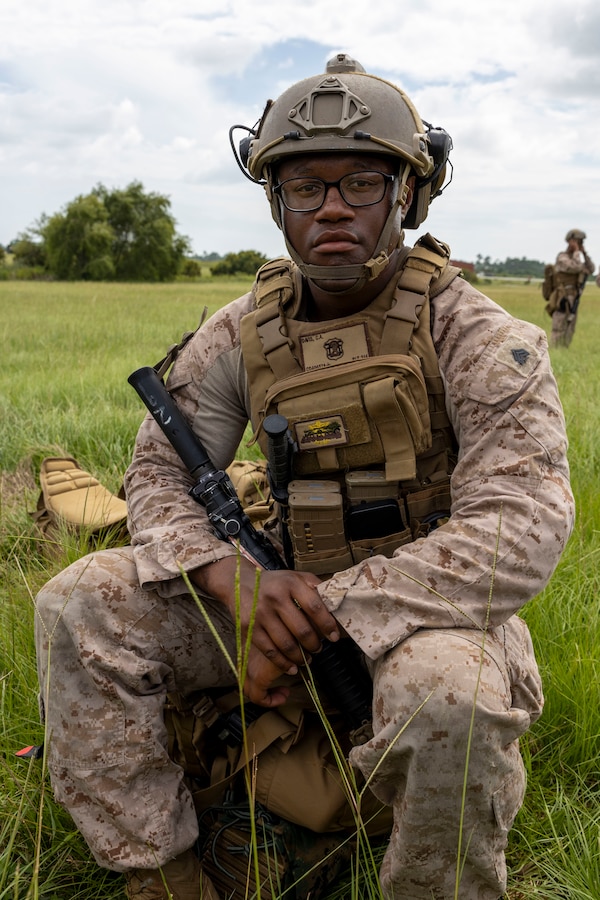 U.S. Marine Corps Sgt. Christophe Davis, a transmissions systems operator with 2nd Air Naval Gunfire Liaison Company, II Marine Expeditionary Force Information Group, poses for a portrait during exercise Burmese Chase 25 at Marine Corps Auxiliary Landing Field Bogue, North Carolina, Aug. 7, 2025. Burmese Chase is an annual U.S. led, multi-lateral training exercise comprised of integrating ground and air fires, infantry tactics and naval gunfire alongside NATO allies to enhance combat readiness and interoperability. (U.S. Marine Corps photo by Cpl. Marc Imprevert)