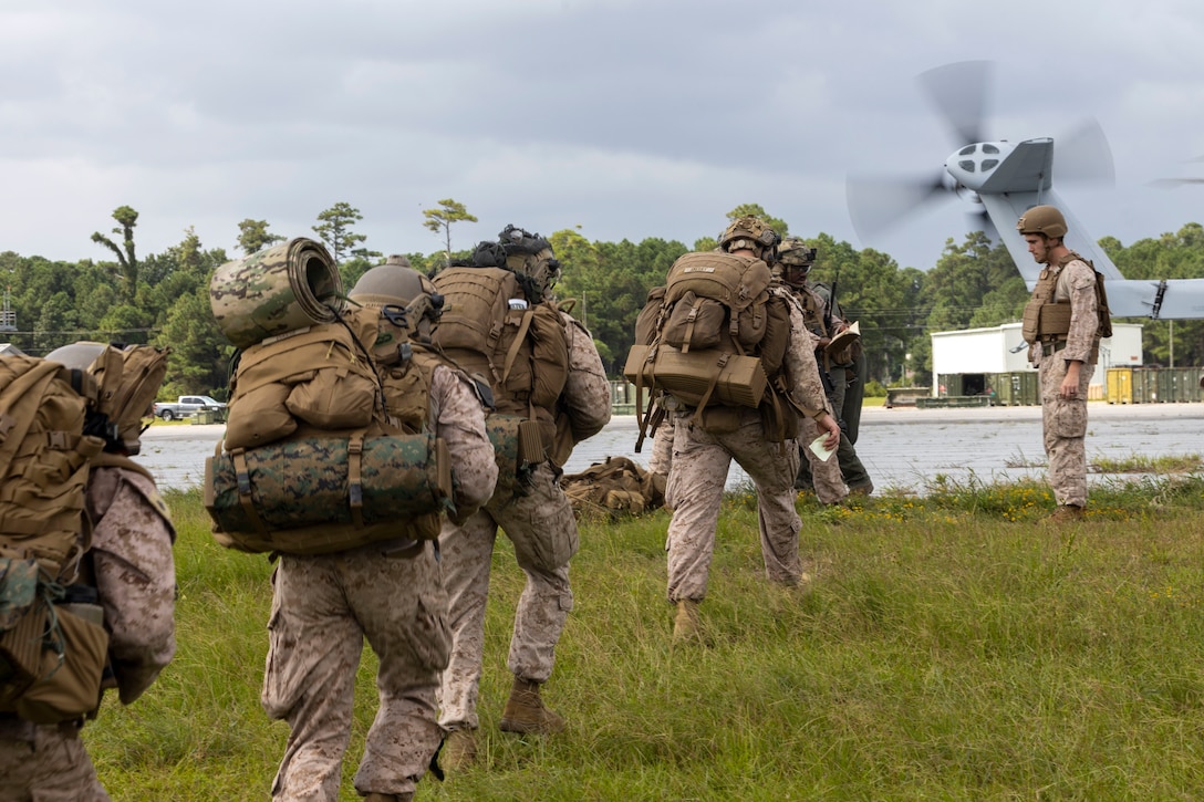 U.S. Marines with 2nd Air Naval Gunfire Liaison Company, II Marine Expeditionary Force Information Group, prepare to board a CH-53E Super Stallion with Marine Heavy Helicopter Squadron 461, Marine Aircraft Group 29, 2nd Marine Aircraft Wing, during exercise Burmese Chase 25 at Marine Corps Auxiliary Landing Field Bogue, North Carolina, Aug. 7, 2025. Burmese Chase is an annual U.S. led, multi-lateral training exercise comprised of integrating ground and air fires, infantry tactics and naval gunfire alongside NATO allies to enhance combat readiness and interoperability. (U.S. Marine Corps photo by Cpl. Marc Imprevert)
