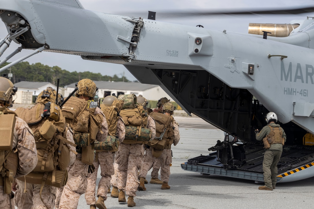 U.S. Marines with 2nd Air Naval Gunfire Liaison Company, II Marine Expeditionary Force Information Group, prepare to board a CH-53E Super Stallion with Marine Heavy Helicopter Squadron 461, Marine Aircraft Group 29, 2nd Marine Aircraft Wing, during exercise Burmese Chase 25 at Marine Corps Auxiliary Landing Field Bogue, North Carolina, Aug. 7, 2025. Burmese Chase is an annual U.S. led, multi-lateral training exercise comprised of integrating ground and air fires, infantry tactics and naval gunfire alongside NATO allies to enhance combat readiness and interoperability. (U.S. Marine Corps photo by Cpl. Marc Imprevert)