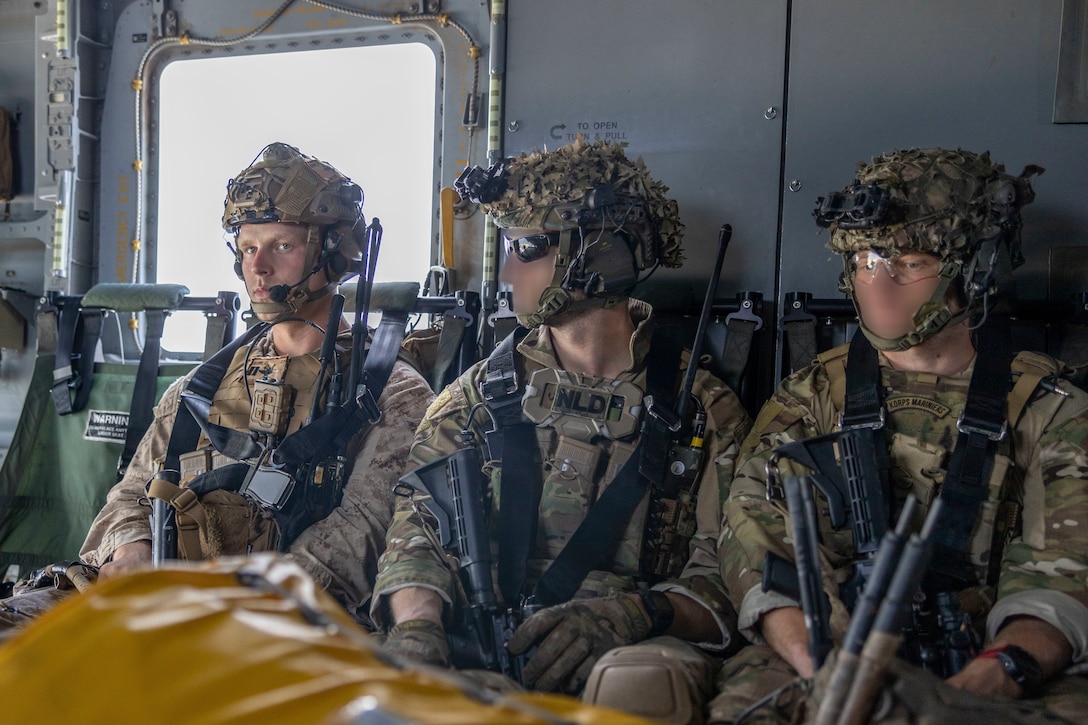 U.S. Marine Corps Capt. Karl Skerry, left, a fire support officer with 2nd Air Naval Gunfire Liaison Company, II Marine Expeditionary Force Information Group, and Dutch Marines with 25 RSTA Squadron travel to their objective point aboard a CH-53E Super Stallion with Marine Heavy Helicopter Squadron 461, Marine Aircraft Group 29, 2nd Marine Aircraft Wing, during exercise Burmese Chase 25 at Marine Corps Auxiliary Landing Field Bogue, North Carolina, Aug. 7, 2025. Burmese Chase is an annual U.S. led, multi-lateral training exercise comprised of integrating ground and air fires, infantry tactics and naval gunfire alongside NATO allies to enhance combat readiness and interoperability. (U.S. Marine Corps photo by Cpl. Marc Imprevert) (This photo has been altered for security purposes by blurring out faces.)