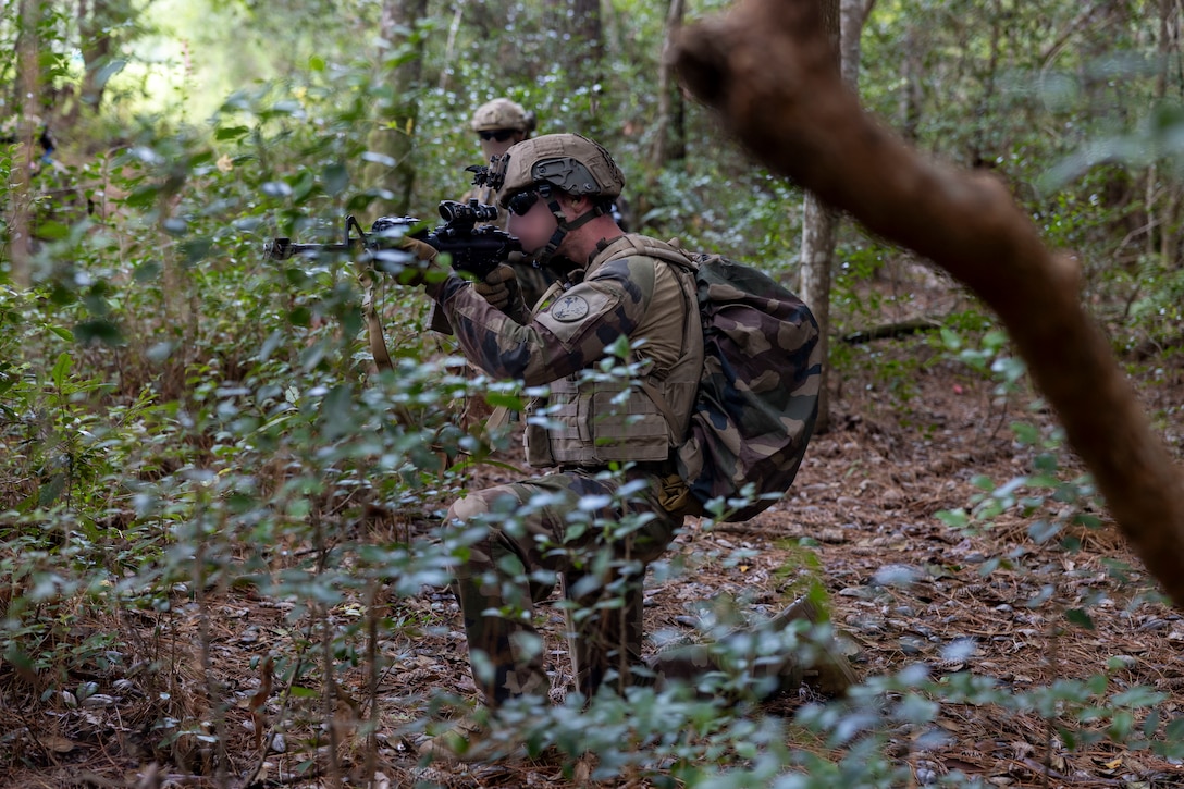 A French Marine with 3rd Marine Artillery Regiment, posts security during exercise Burmese Chase 25 at Marine Corps Base Camp Lejeune, North Carolina, Aug. 7, 2025. Burmese Chase is an annual U.S. led, multi-lateral training exercise comprised of integrating ground and air fires, infantry tactics and naval gunfire alongside NATO allies to enhance combat readiness and interoperability. (U.S. Marine Corps photo by Cpl. Marc Imprevert) (This photo has been altered for security purposes by blurring out faces.)